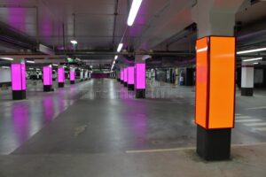 Modernt parkeringsgarage i Stockholm med färgglad belysning.